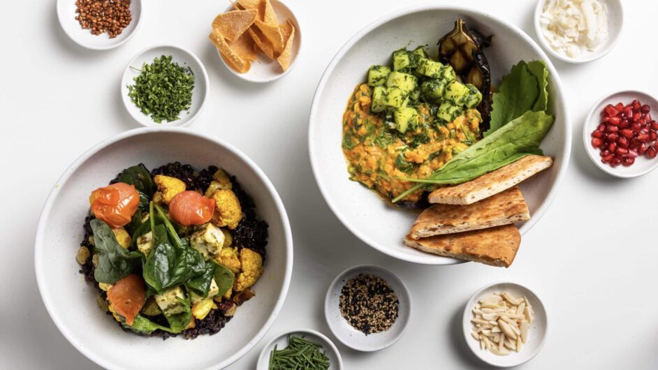 white background with two bowls of hot meals and eight small bowls of toppings.